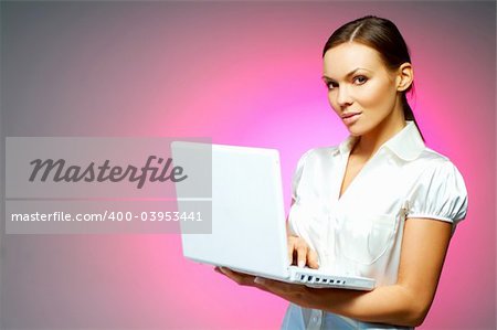 Beautiful and sexy brunette business woman isolated on clear background with laptop computer