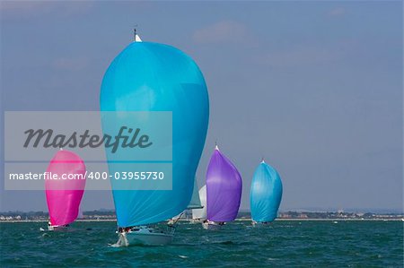 Yachts racing with coloured spinnakers raised