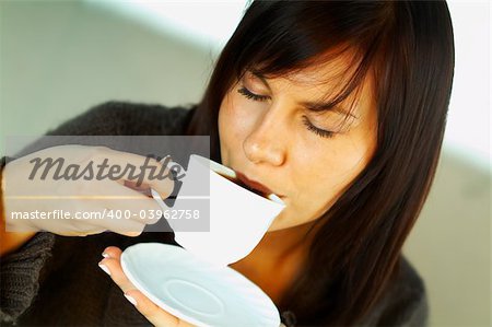 Brunette business woman with white cup of black coffee