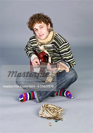 Beatiful young man with guitar on isolated background