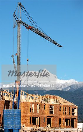 A crane seems to tower over a peak near Whistler, BC, Canada.  Development is booming in the nearby town of Squamish.