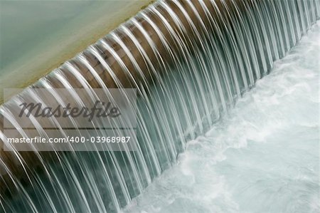 Soft image of water flowing over a dam