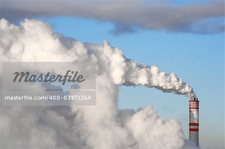 A smoking chimney against a blue sky.