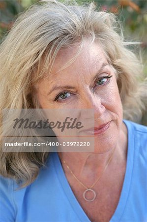 A beautiful, mature blond woman.  Her face shows wisdom and experience.  Vertical view.