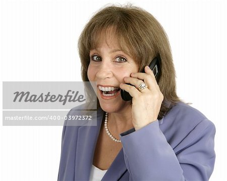 An attractive businesswoman very surprised and happy as she talks on her cellphone.  Isolated.