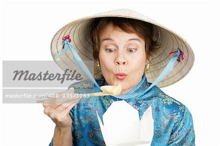 Tourist in Chinese clothing eating a dumpling from a takeout container.  Isolated on white.