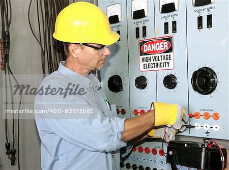 Actual electrician working on an industrial power distribution center. All work shown is being performed according to industry code and safety standards.