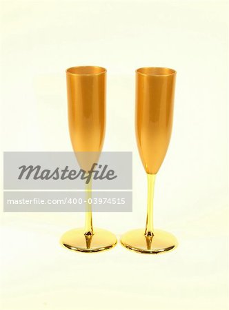 A pair of gold colored champagne glasses ready for a toast.