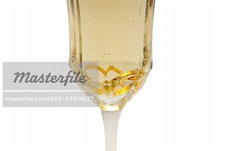A glass of champagne sports two wedding rings that take on a heart shape due to the glass shape..