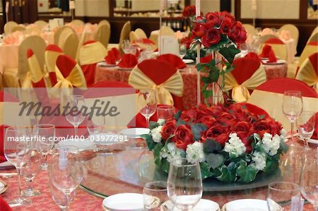 Wedding banquet table setting with a bouquet of red roses