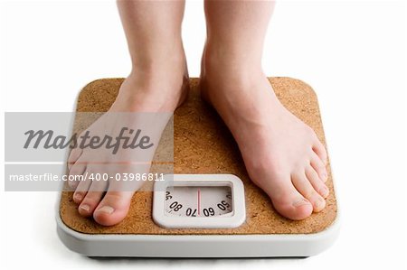 A pair of female feet standing on a bathroom scale