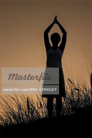 female silhouette celebrating summer sunset, PERSON ISN'T IDENTIFABLE