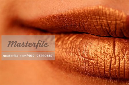 Macro blur image of bright lips -gold lipstik