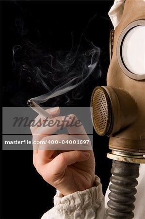 Person in gas mask smoking cigarette on dark background