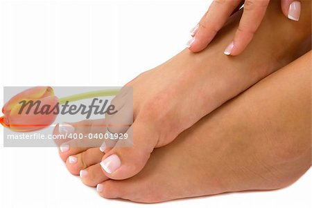 Pedicured foot and manicured hand with an elegant tulip