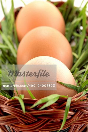 Three Easter eggs in basket with grass, focus on first