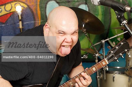 Guitar player with attitude sticking his tongue out while playing.