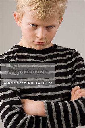 Portrait of a angry little boy posing on white background