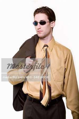 Portrait of a confident handsome young brunette business man wearing yellow dress shirt and matching tie holding jacket over shoulder standing looking to the side wearing dark sunglasses