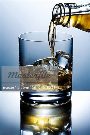 Filling of a glass of whisky with ice