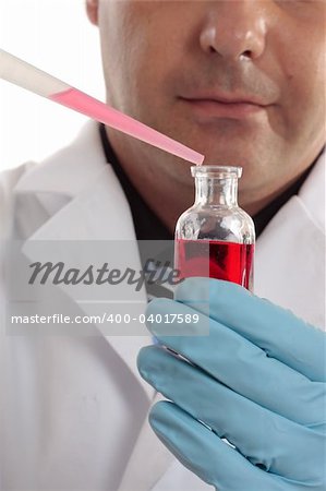 A scientist, chemist or pharmacist conducting laboratory research. Focus to bottle and pipette.