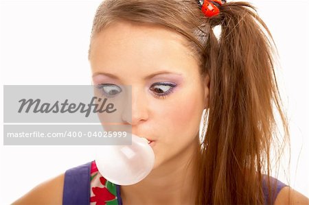 The amusing girl has become cross-eyed, looking on the inflated bubble, on a white background