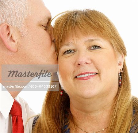 Closeup of a beautiful plus sized woman getting a kiss from a handsome guy.  White background.