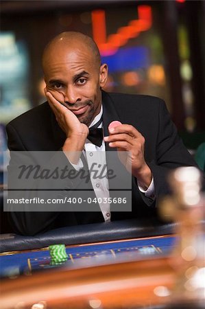 Man losing at roulette table in casino