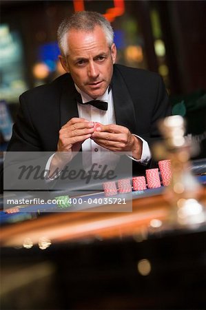 Man gambling at roulette table in casino