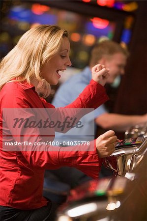 Woman celebrating win on slot machine at casino