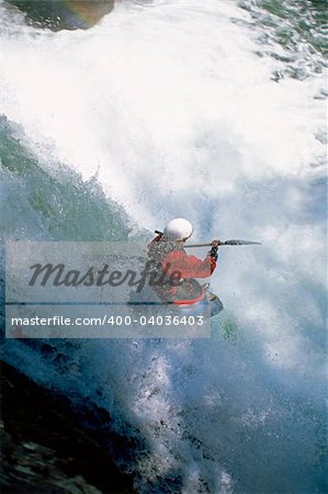 Young woman kayaking in rapids