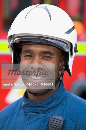 Portrait of a firefighter standing in front of a fire engine