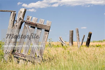old broken fence door hangs crooked on a post