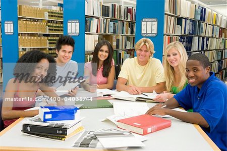 Group of six students working around table in library
