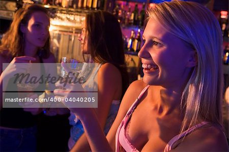 Three young women drinking at a nightclub