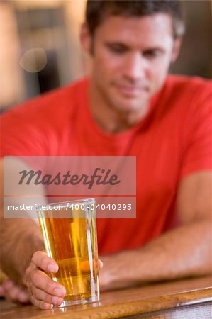 Young man relaxing at a bar with a beer