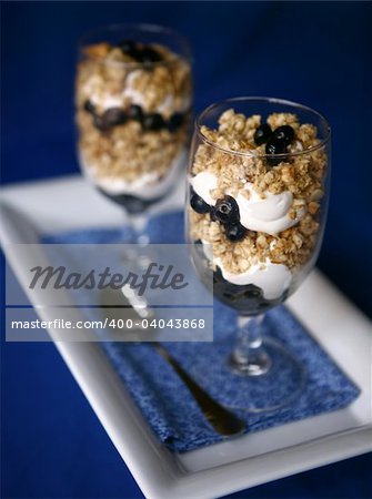 Delicious Treat of Blueberries Yogurt and Granola Shot in High Depth of Field Focus is on First Glass