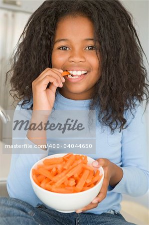 Girl eating bowl of carrots