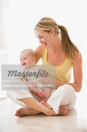 Mother and baby sitting indoors smiling