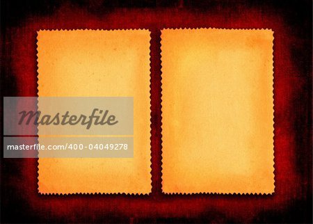 two pieces of yellowed paper on red textile background