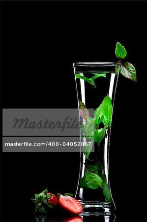View of long glass filled with fresh drink on black back