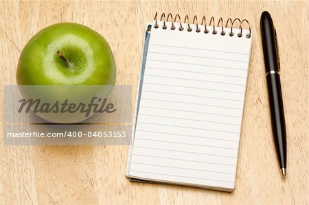 Pen, Paper and Apple on a Wood Background