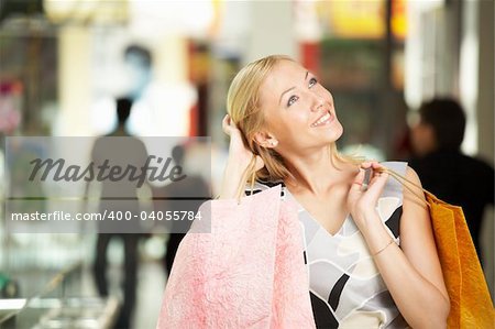 Portrait of the smiling blonde in shop with bags