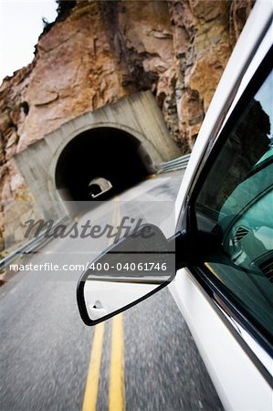 car driving approaching tunnel through the mountains