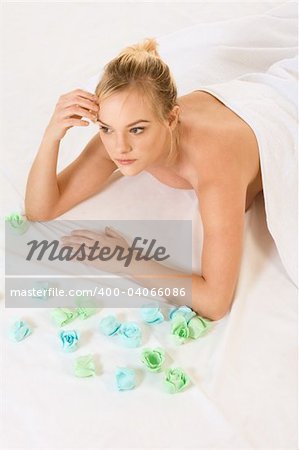 Beautiful girl relaxing in spa surrounded by aromatherapy items