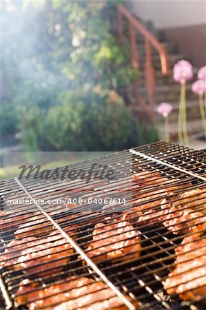 Meat cooking on barbeque grill with flames