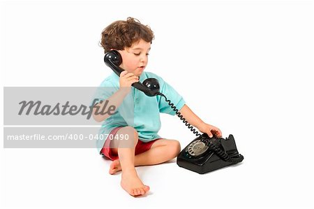 young boy talking on a retro phone isolated on white