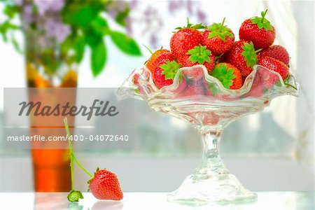 High key photo of fruit dish filled with nice red strawberries