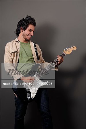 Portrait of young handsome musician playing electric guitar