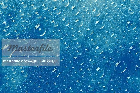 Blue water drops on a glass surface.